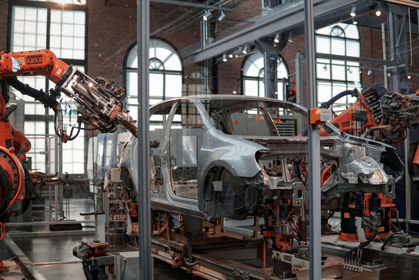 Car bodies on an assembly line between robot arms