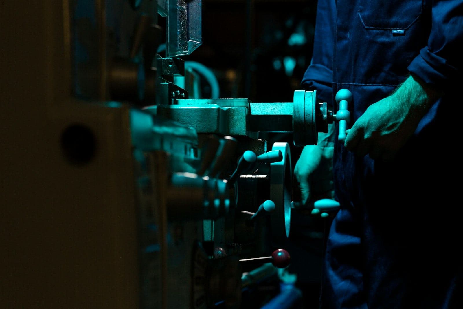 A machine on a dim factory floor lit in green