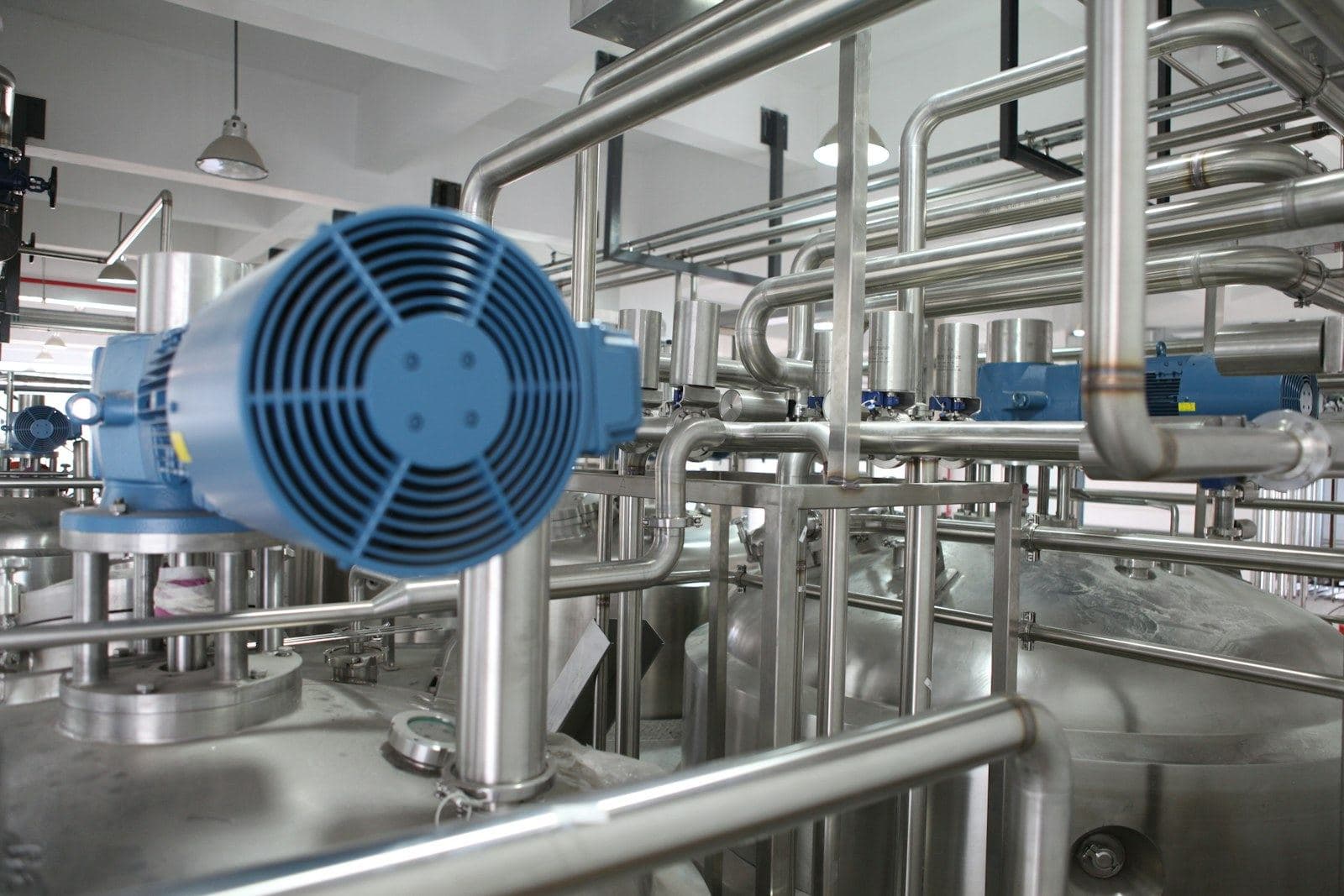Steel pipework and a blue fan unit in a plant room