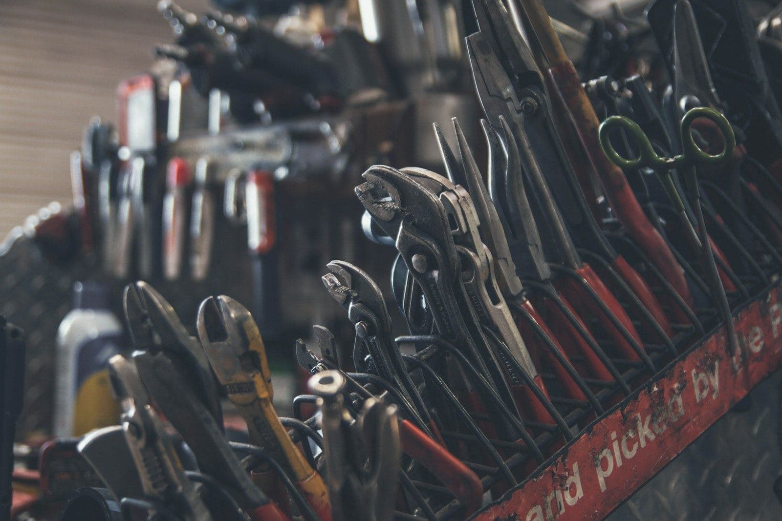 Hand tools hanging in rows on a workshop wall